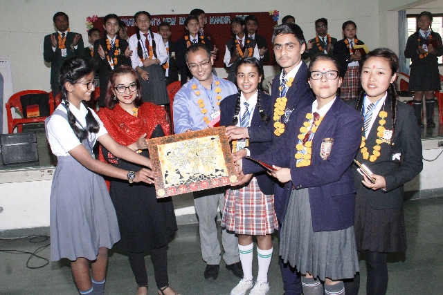 Vaishnavi Mane from Std. IX presenting a Canvas painted by her to the guests as a memoir.
